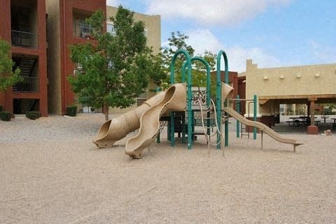 a playground with some slides in the sand